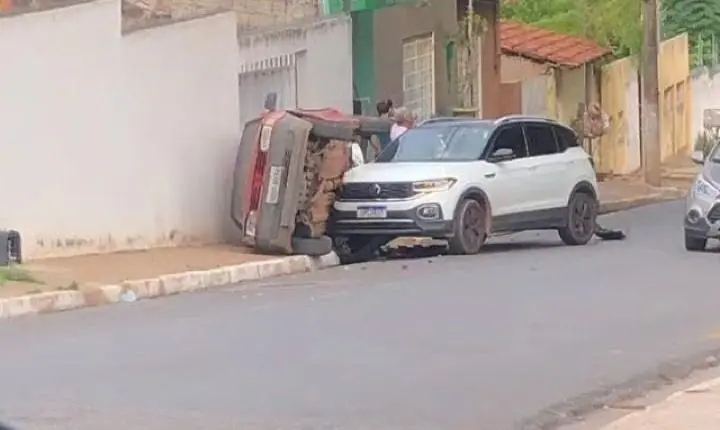 Batida entre dois carros termina com veículo virado junto a muro em Cuiabá